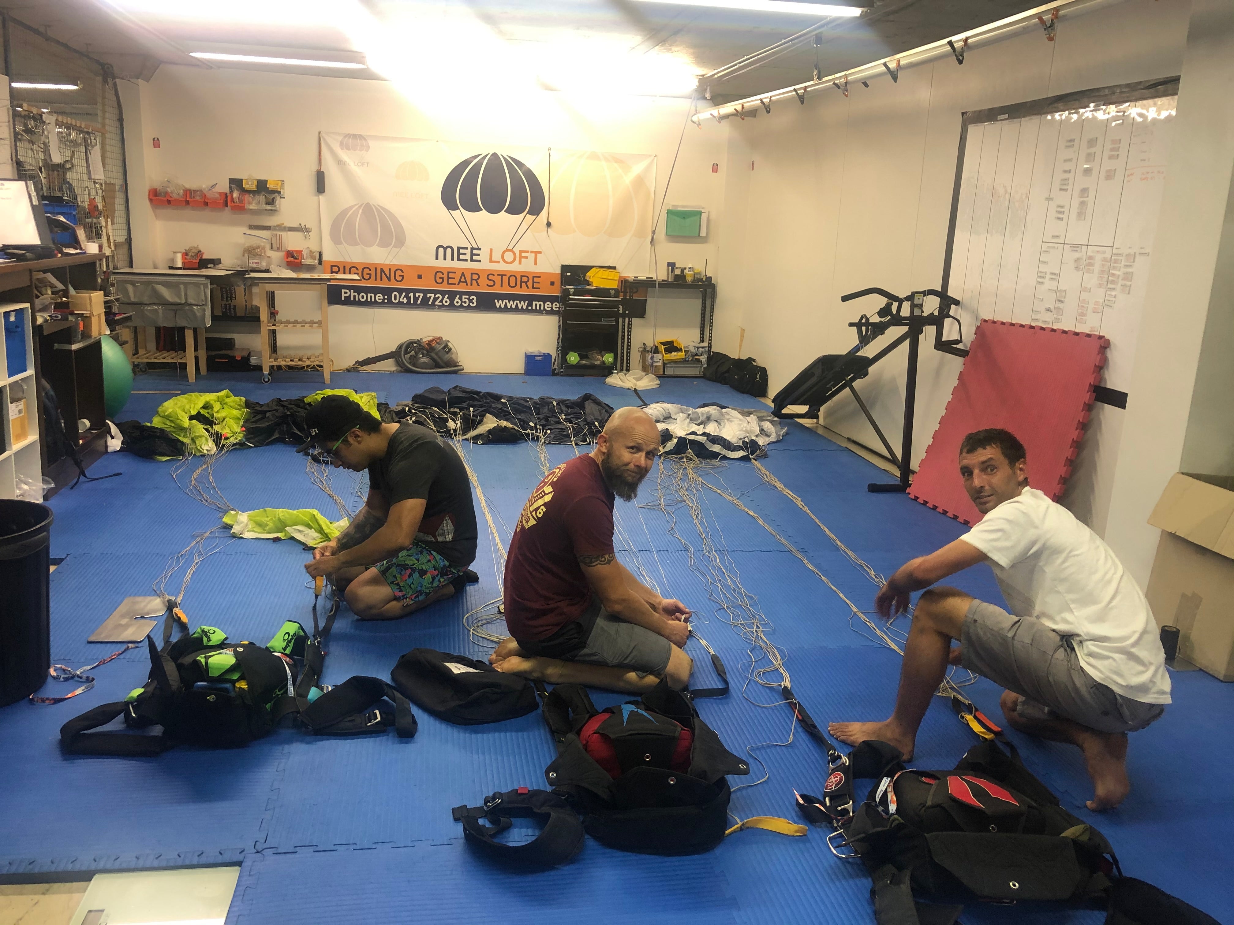 Skydivers working on parachute gear at Mee Loft Monthly Maintenance